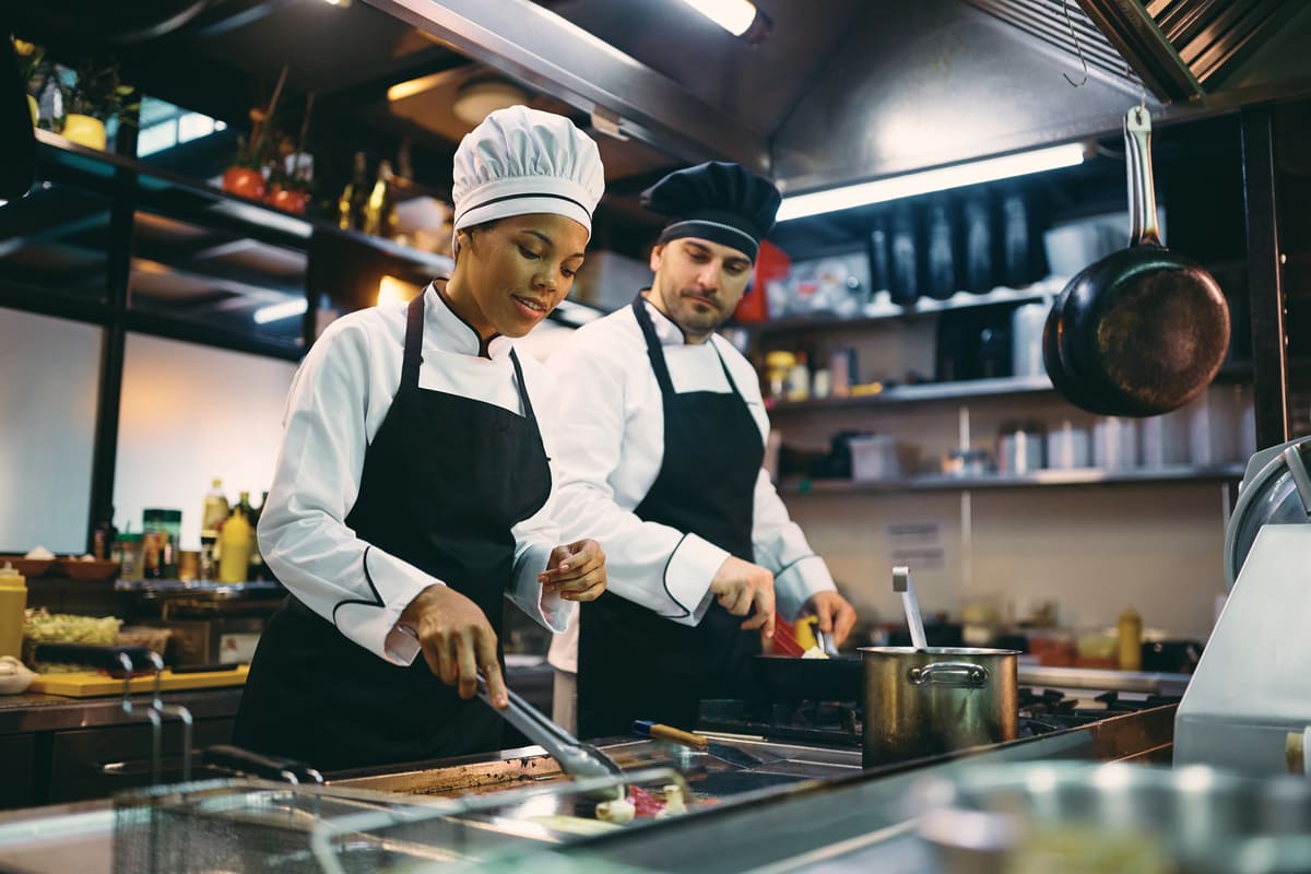 Cuisinier en train de préparer un plat dans une cuisine professionnelle