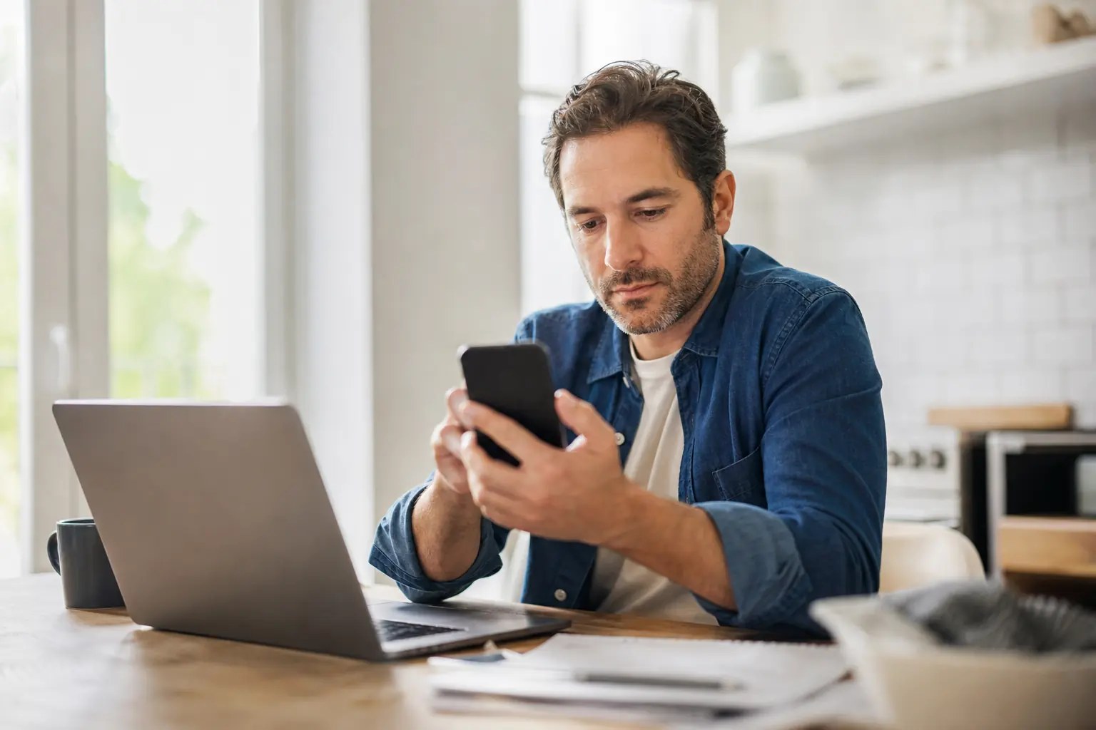 Smartphone affichant une application pour faire ses comptes avec graphique des dépenses et solde du mois